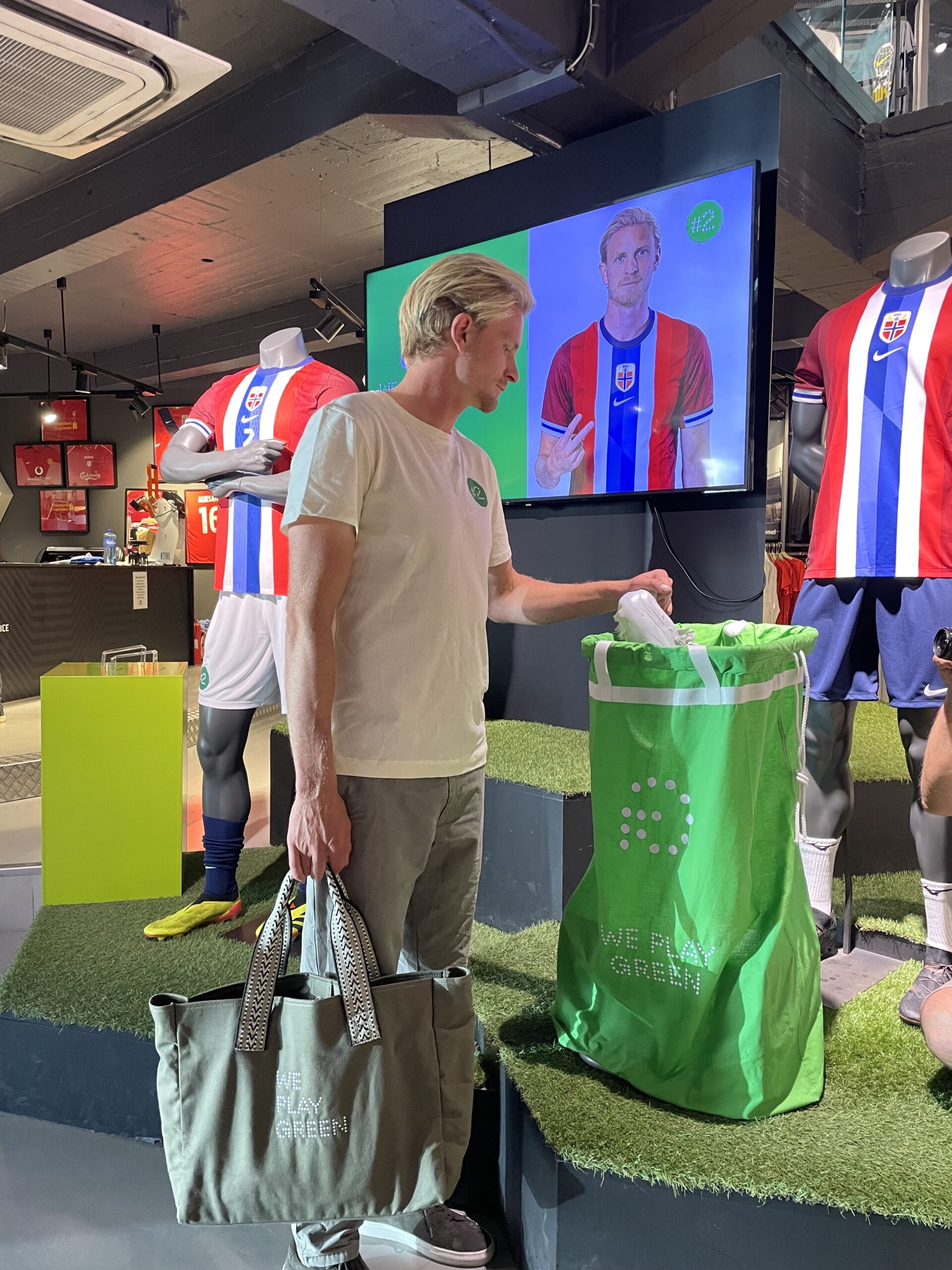 Man putting a pair of football shoes in a green bag