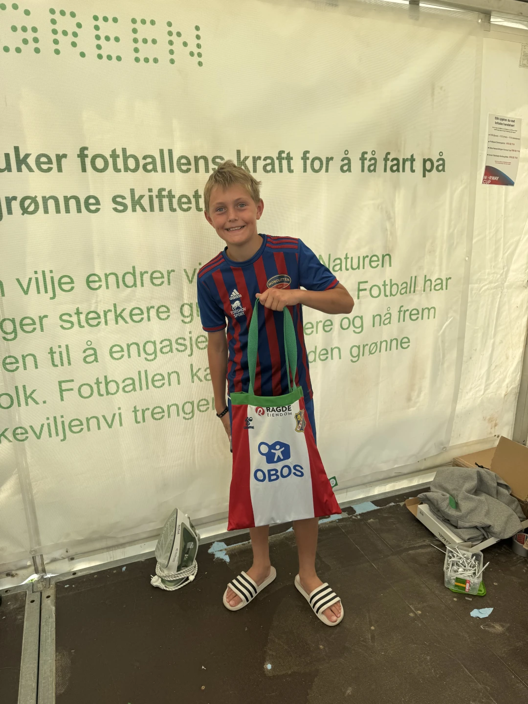 We Play Green young boy player at stand at Norway Cup